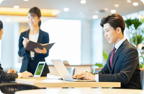 オフィスで同僚と打ち合わせをする若手ビジネスマン